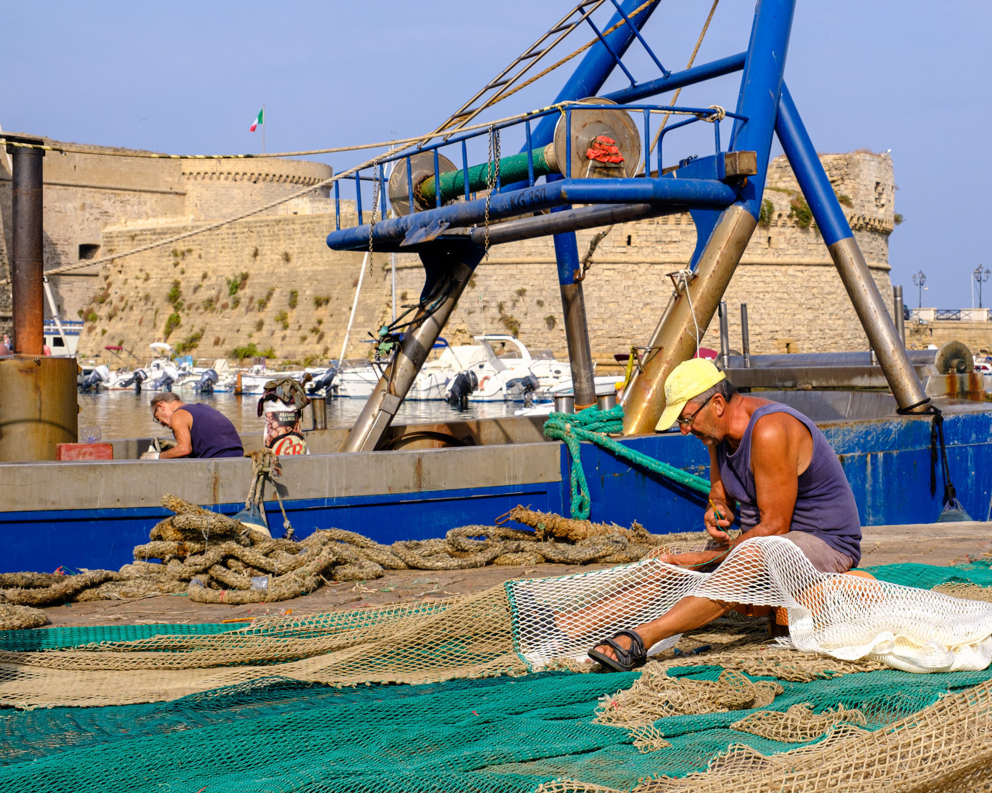 Fishermen mending the nets in Gallipoli Puglia