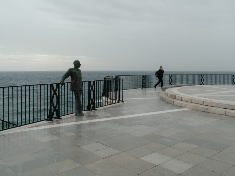 Solo turist in Balcon Europa during a cloudy day in Nerja Spain