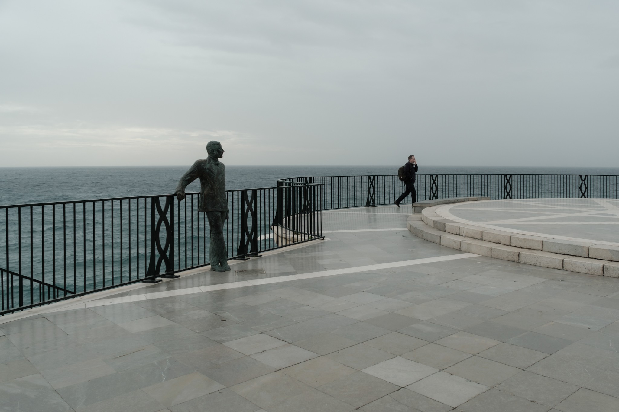 Solo turist in Balcon Europa during a cloudy day in Nerja Spain