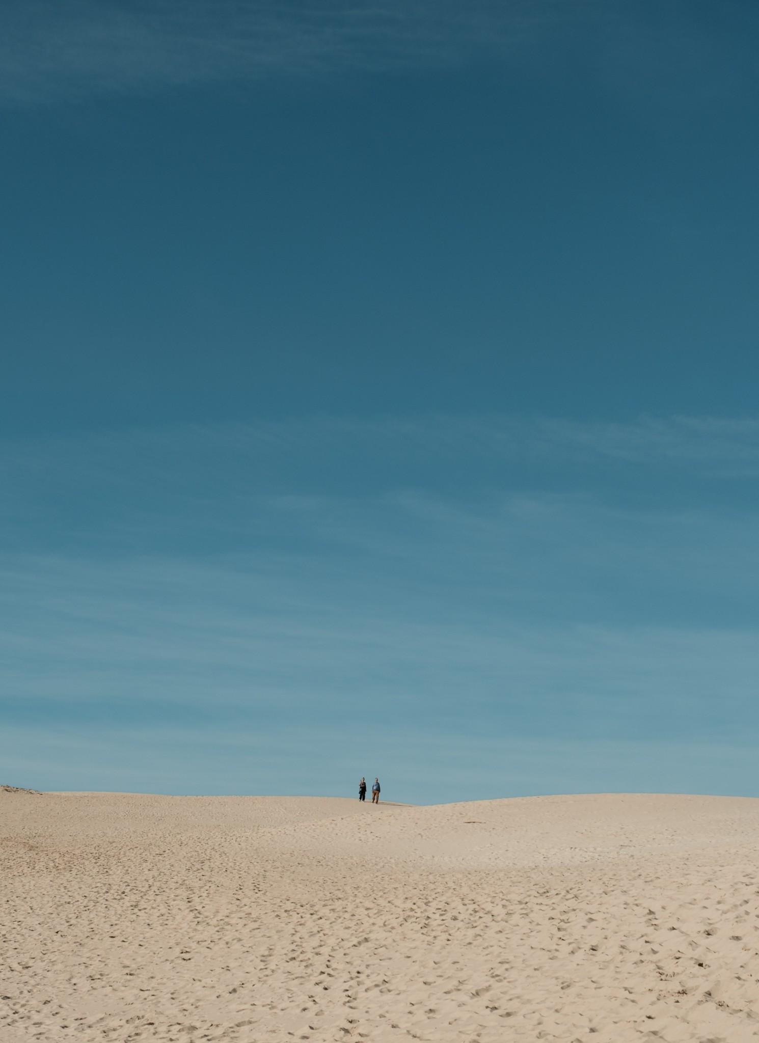 A couple descending on the dunes of Bolonia Andalusia