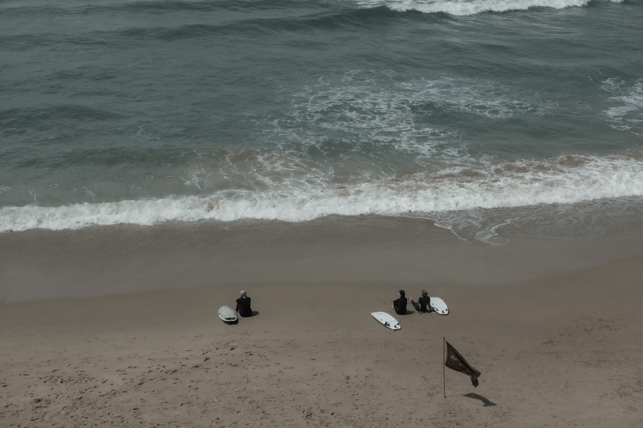 Surfers resting at Arrifana beach Algarve